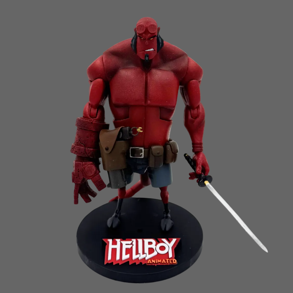 Hellboy collectible figure on a black display base with the Hellboy Animato logo, shown against a plain white background.