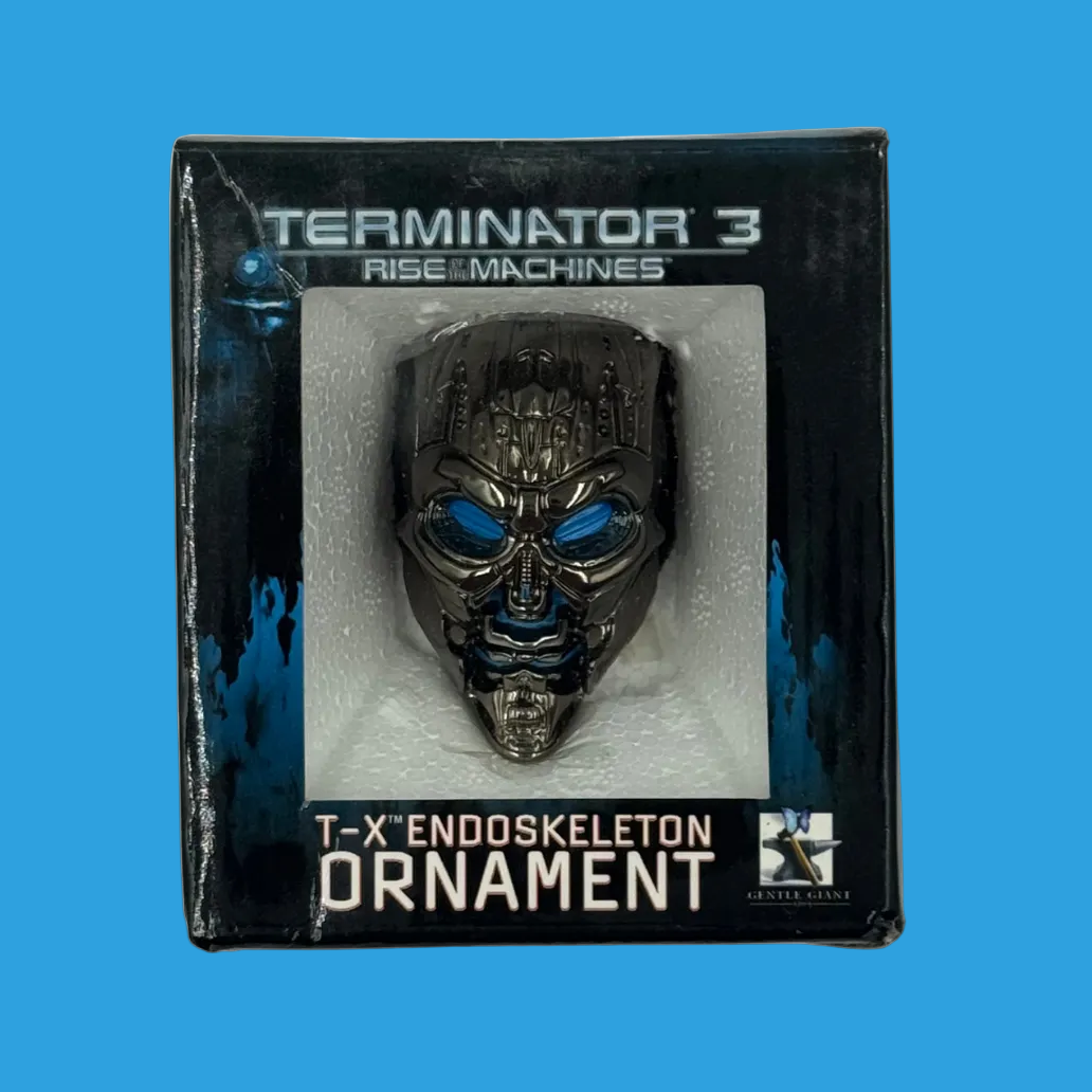 Terminator 3 T-X Endoskeleton Ornament in its original retail packaging, featuring a metallic skull ornament with glowing blue eyes.